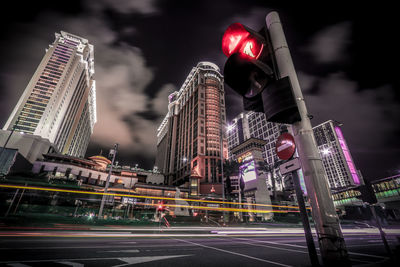 Low angle view of illuminated buildings in city against sky at night