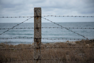 Travel restrictions. the sea beyond the fence with barbed wire