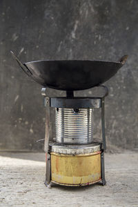 Close-up of utensil on camping stove by wall