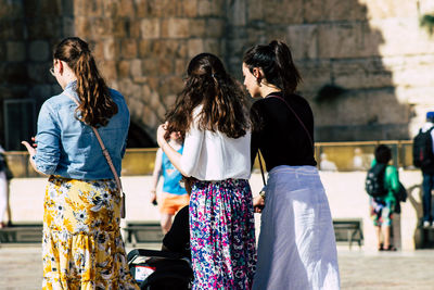 Rear view of women walking in city