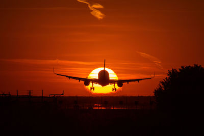 Airplane flying in sky during sunset