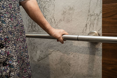 Low section of man holding woman standing on metal railing