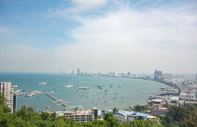 High angle view of cityscape by sea against sky