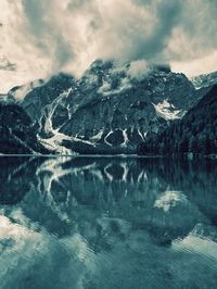 Scenic view of lake by snowcapped mountains against sky