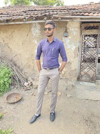 Full length of young man standing against wall