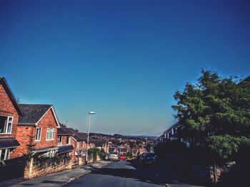 Street amidst buildings in town against blue sky