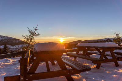 Scenic view of snowcapped mountains against clear sky during sunset