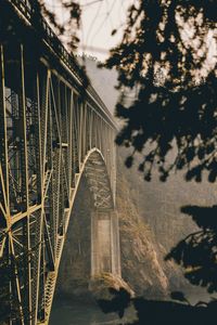 Arch bridge over river against sky