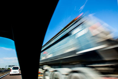 Blurred motion of car on street in city against sky