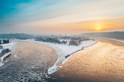 Aerial view of sea against sky during sunset in winter