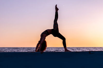 Full length of man on beach against sky during sunset