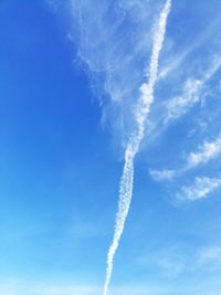 Low angle view of airplane flying against blue sky