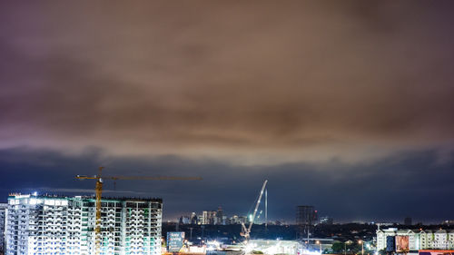 Illuminated cityscape against sky at night