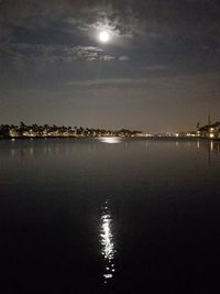 Illuminated sea against sky at night