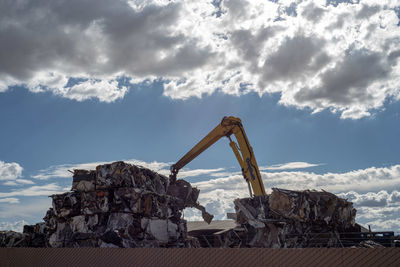 Low angle view of damaged rock against sky