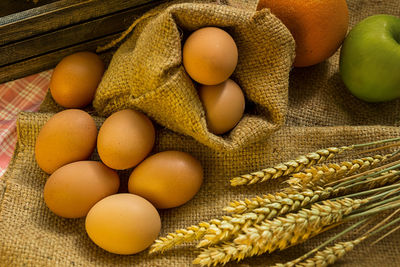 Breakfast and baked bread concept. fresh fragrant bread and egg and apple on the fabric sack. 