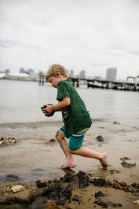 Full length of boy on beach against sky