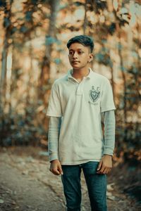 Portrait of young man standing in forest