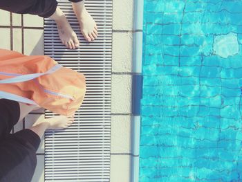 Low section of people standing by swimming pool