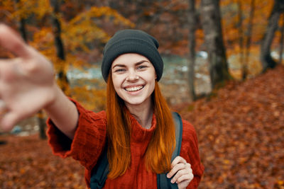Portrait of smiling young woman during autumn