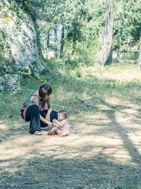 Mother and daughter sitting on tree