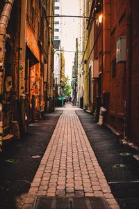 Narrow street amidst buildings in city at night