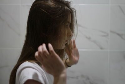 Portrait of girl with arms raised at home