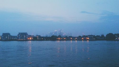 View of illuminated cityscape against blue sky