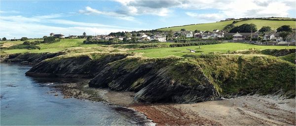 Panoramic shot of houses by riverbank against sky