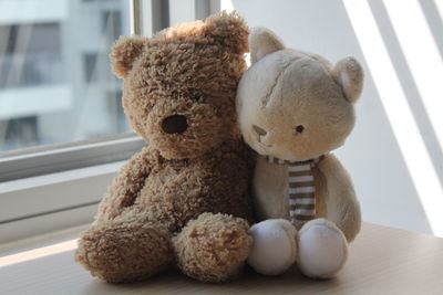 Close-up of stuffed toys on table by window