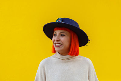 Portrait of smiling young man against yellow wall