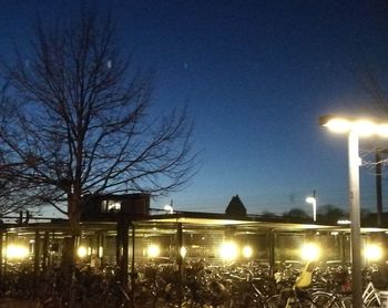 Illuminated street light against sky at night