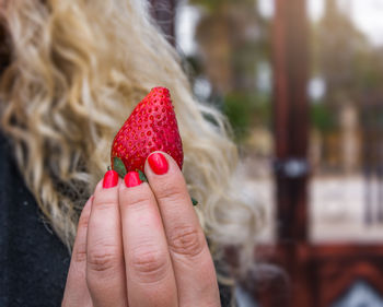 Close-up of woman hand holding strawberry