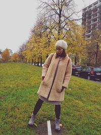 Full length of woman standing in park during winter