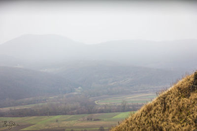 Scenic view of field and mountains against sky