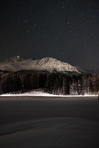 Scenic view of snowcapped mountains against sky at night