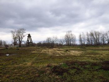 Scenic view of grassy field against cloudy sky