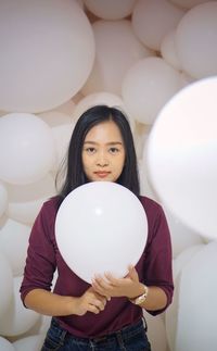Portrait of a young woman holding balloons
