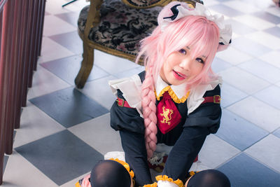High angle portrait of smiling woman sitting on floor