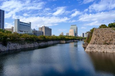 River amidst buildings in city against sky