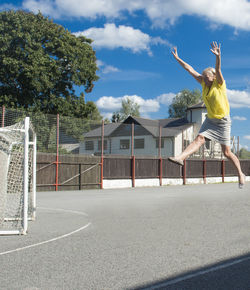 Full length of woman jumping at playing field