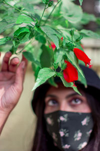 Close-up portrait of woman holding plant