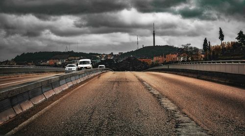 Road by bridge against sky