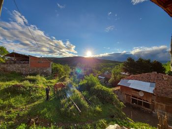 Houses and buildings against sky on sunny day