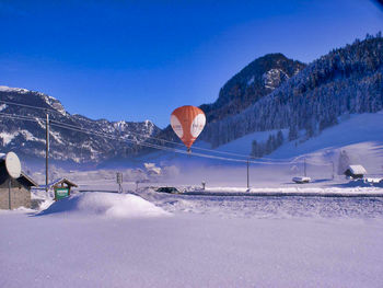 Scenic view of snow covered mountains against blue sky