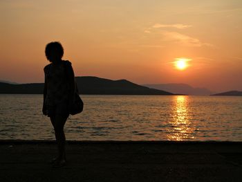 Silhouette of man in sea at sunset