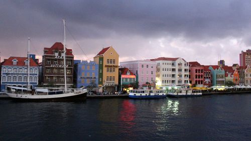 Boats in river against buildings in city