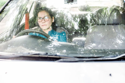 Portrait of happy young woman in car