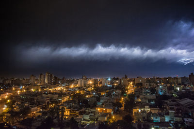 High angle view of illuminated city against sky at night