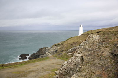 Lighthouse by sea against sky